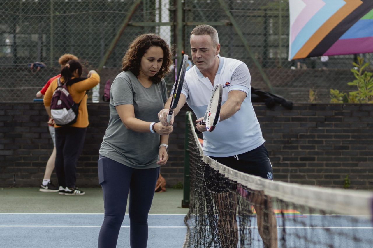An LGBTQ+ sport session taking place on a tennis court